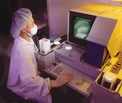 An inspector at Crystal Technology checks wafers that the company produces for acousto-optic components. Test specifications and An inspector at Crystal Technology checks wafers that the company produces for acousto-optic components. Test specifications and