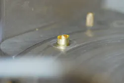 The cold-forming process causes shell casings to have an uneven mouth. This view shows the casing mouth protruding upward throug The cold-forming process causes shell casings to have an uneven mouth. This view shows the casing mouth protruding upward throug