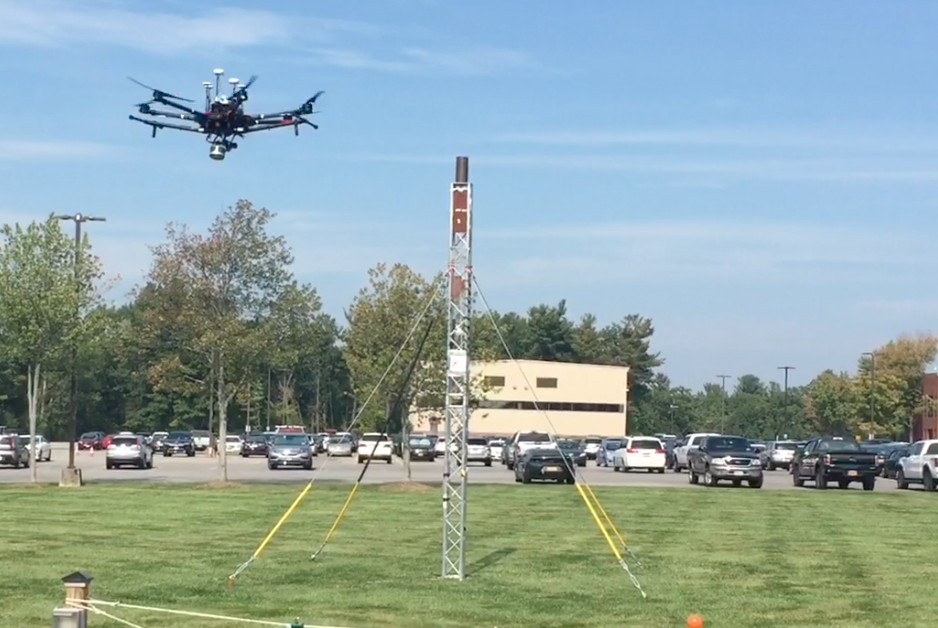 At an outdoor test site at GE Global Research, a drone flies around a small tower to create a 3D model of the asset.