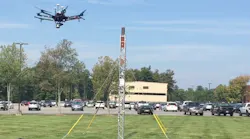 At an outdoor test site at GE Global Research, a drone flies around a small tower to create a 3D model of the asset.