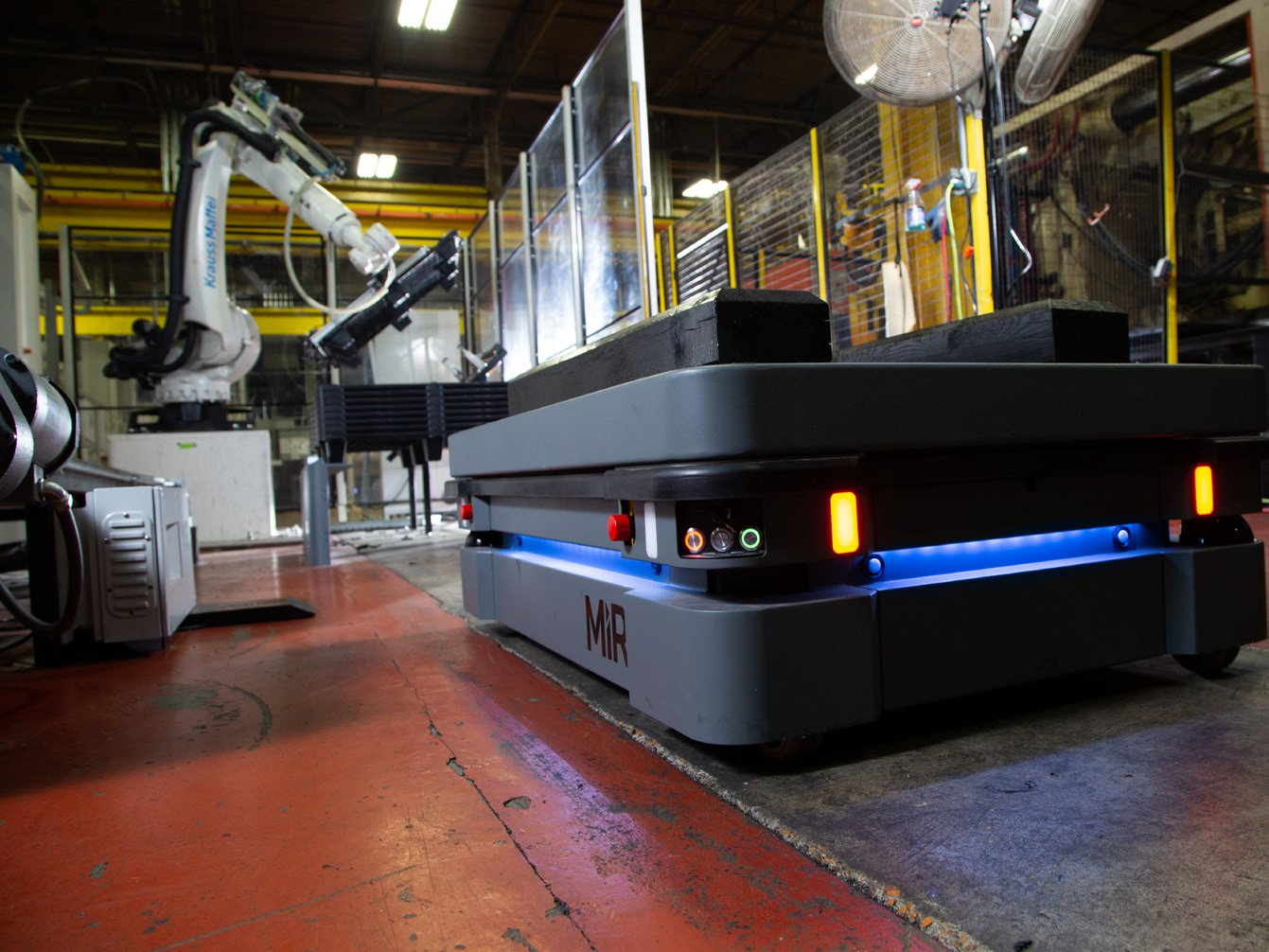 The MiR500 robot approaches the injection molding machine and its attendant robot.