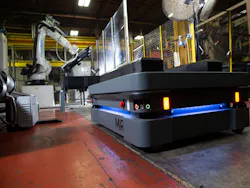 The MiR500 robot approaches the injection molding machine and its attendant robot. The MiR500 robot approaches the injection molding machine and its attendant robot.