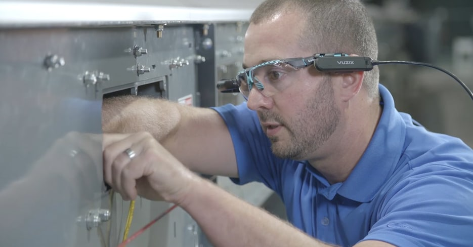 Worker using Honeywell Intelligrated's TechSight to receive guided maintenance assistance.