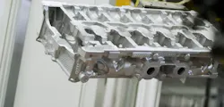 An aluminum power train component following removal from the sand core mold. An aluminum power train component following removal from the sand core mold.