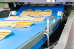 Close up bologna sliced plate on conveyor of automatic slicer machine for industrial food manufacturer Close up bologna sliced plate on conveyor of automatic slicer machine for industrial food manufacturer