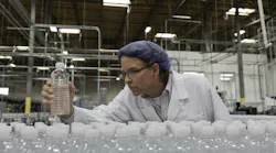 Quality control worker checking bottled water at bottling plant