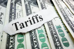 The word 'Tariffs' typed on a scrap of paper laid atop several $100 bills The word 'Tariffs' typed on a scrap of paper laid atop several $100 bills