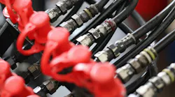 Close up of industrial hydraulic hoses with connectors and red protective dust caps, professional fluid power system for heavy machinery engineering and maintenance. Close up of industrial hydraulic hoses with connectors and red protective dust caps, professional fluid power system for heavy machinery engineering and maintenance.