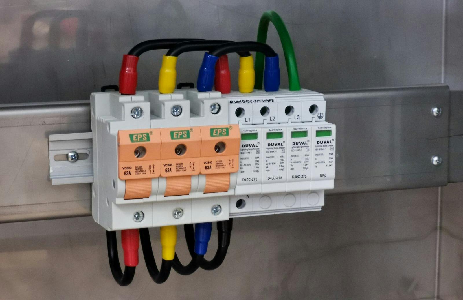 Photo of switch fuse and surge protection device connection in electrical cabinet.