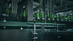 Rows of green glass bottles gliding along a conveyor belt inside an industrial brewery, moving through quality control machinery designed for efficient production and inspection Rows of green glass bottles gliding along a conveyor belt inside an industrial brewery, moving through quality control machinery designed for efficient production and inspection