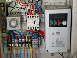 Close-up of an industrial electric control panel, featuring a digital Variable Frequency Drive (VFD), relay, and wiring. Close-up of an industrial electric control panel, featuring a digital Variable Frequency Drive (VFD), relay, and wiring.