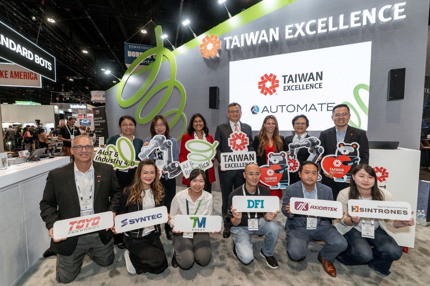 Members from Taiwanese Excellence award-winning companies at the Taiwan Excellence Pavilion during the 2026 Automate show pose together holding up their company signs.